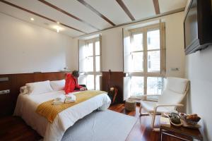 a child sitting on a bed in a bedroom at Hotel Santa Clara in Santiago de Compostela