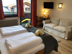 una camera d'albergo con due letti e un divano di Magali's, Bed & Breakfast - former Pension Andrea a Zell am See