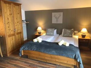 a bedroom with a large bed with two lamps at Magali's, Bed & Breakfast - former Pension Andrea in Zell am See