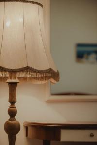 a lamp sitting next to a table with a window at Nonna's Boutique Hotel in Dhërmi