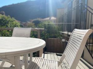 2 chaises blanches et une table sur un balcon dans l'établissement La Mia Casa A Finalborgo, à Finale Ligure