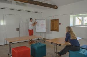a man and a woman in a classroom with a whiteboard at Apartment Mauser-Mühltaler in Mauterndorf