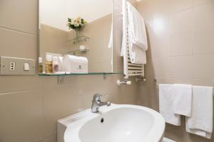 W łazience znajduje się umywalka, lustro i ręczniki. w obiekcie Contempora Apartments - Elvezia 8 - E54 w Mediolanie +5 zdjęć