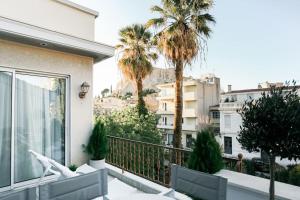 a balcony with palm trees and a view of a city at Acropolis Veranda Residence in Athens