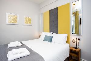 a bedroom with a white bed with towels on it at Stay Coastal in Whitley Bay