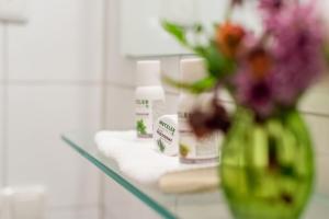 a vase of flowers on a counter in a bathroom at Apartments Susanne in Au im Bregenzerwald