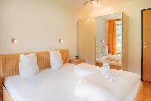 a bedroom with two beds and a mirror at Apartments Susanne in Au im Bregenzerwald