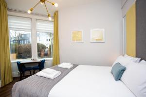 a bedroom with a bed and a table and a window at Stay Coastal in Whitley Bay