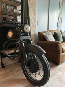Una bicicleta estacionada en una sala de estar junto a un sofá en Le rétro en Verdun