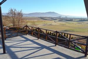 a wooden railing on a balcony with a view of a field at Penzión Hoffer in Nitra