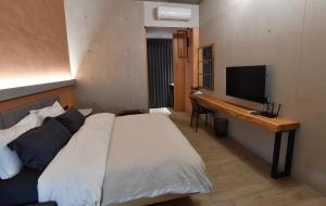 a bedroom with a bed and a desk with a television at 傅居52 in Tainan