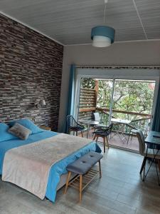 um quarto com uma cama e uma parede de tijolos em La Croisee des Sentiers em Salazie