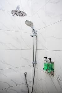 a shower with a shower head in a bathroom at Stay Coastal in Whitley Bay