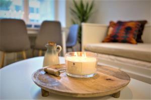 a candle on a wooden table in a living room at Viihtyisä & Varusteltu Keskusta-asunto Neljälle! in Tampere