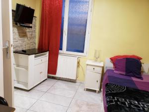 a small bedroom with a bed and a window at LE CEDRE in Saint-Denis