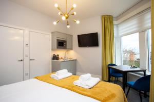 a bedroom with a bed with two towels on it at Stay Coastal in Whitley Bay