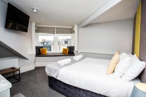 a bedroom with a large bed and a window at Stay Coastal in Whitley Bay