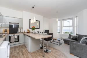 een keuken en een woonkamer met een tafel en een bank bij Sea Views Stunning 2 Bedroom Apartment # in Lowestoft