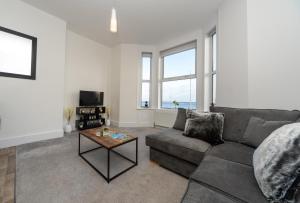 een woonkamer met een bank en een tafel bij Sea Views Stunning 2 Bedroom Apartment # in Lowestoft