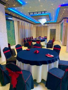 un salón de banquetes con mesas y sillas con arcos rojos en ruwanara royal majestry en Ambagahagedara