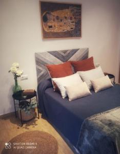a bedroom with a blue bed with red and white pillows at Cómodo adosado en San Bartolomé in San Bartolomé de la Torre