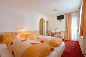 ein Hotelzimmer mit 2 Betten und einem Tisch in der Unterkunft Gästehaus Sillaber-Gertraud Nuck in Söll