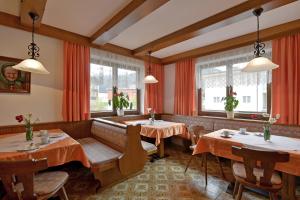 een restaurant met 2 tafels en 2 ramen bij Gästehaus Sillaber-Gertraud Nuck in Söll