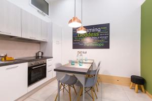 a kitchen with a table and chairs and a sign on the wall at BAUBO sulla via dei presepi by Napoliapartments in Naples