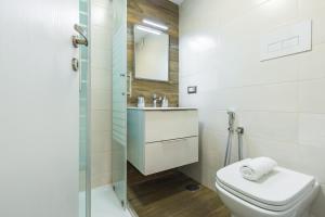 a bathroom with a toilet and a sink and a shower at BAUBO sulla via dei presepi by Napoliapartments in Naples