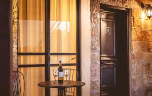 a table with a bottle of wine and two glasses at Sheva Hotel Gilboa in Maalé-Hagilbo‘a