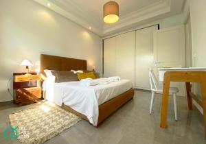 a bedroom with a bed and a table and a desk at Le Safran - apt renove, spacieux et central a Marsa in Carthage