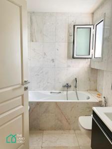 a bathroom with a tub and a toilet and a sink at Le Safran - apt renove, spacieux et central a Marsa in Carthage