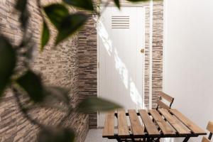 una panca di legno seduta di fronte a una porta bianca di Casa da Vila River & Sea in Porto-Family & Friends a Porto