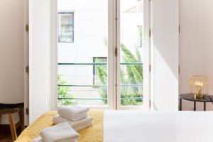 Zimmer mit einem großen Fenster und Handtüchern auf einem Bett in der Unterkunft Casa da Vila River & Sea in Porto-Family & Friends in Porto