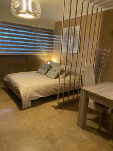 Schlafzimmer mit einem Bett, einem Tisch und einem Fenster in der Unterkunft Beach-studio in Antibes
