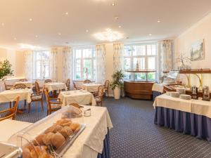 a dining room with tables and chairs and tablesktop at Park-Hotel in Timmendorfer Strand