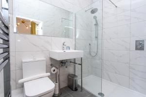 a white bathroom with a sink and a shower at Stay Coastal in Whitley Bay +37 photos