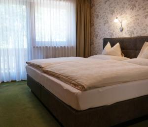 ein Schlafzimmer mit einem großen Bett und einem Fenster in der Unterkunft Gästehaus Hochmuth in Mayrhofen