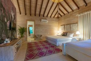 a bedroom with two beds and a wooden wall at Villa Lukka in Cıralı