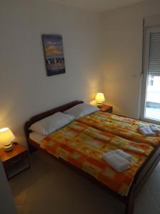 1 dormitorio con 1 cama con 2 lámparas y 2 toallas en Apartments Milic-Ulcinj, en Ulcinj