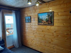 a room with a wooden wall with a picture on it at Котедж "Смерековий затишок" in Vorokhta