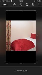 a picture of a bed with a red blanket at wingate cottage in Southburgh