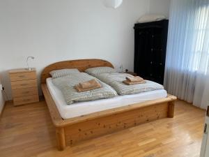 ein Schlafzimmer mit einem Holzbett mit zwei Kissen darauf in der Unterkunft Haus Mühlenberg in Arnsberg