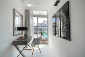 a white room with a desk and a window at Kikar Boutique Hotel in Netanya