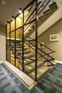 a metal staircase in a basement with glass railing at Kikar Boutique Hotel in Netanya