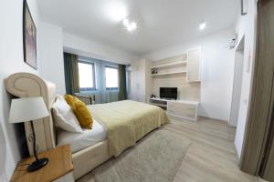 a white bedroom with a bed and a television at Avenue Parliament Old Town - Avenue Hotels in Bucharest