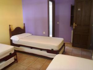 2 camas individuales en una habitación con paredes moradas en Albergue Las Almunias, en Las Almunias