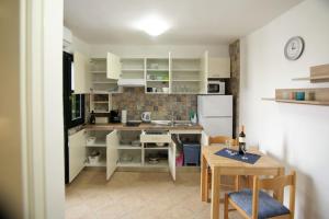a kitchen with white cabinets and a table and a dining room at Apartment Ljubica Tisno in Tisno