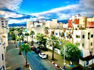 a view of a city with palm trees and buildings at Hôtel Réstinga Martil in Martil