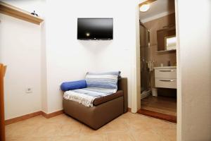 a living room with a couch and a tv on the wall at Apartment Ljubica Tisno in Tisno